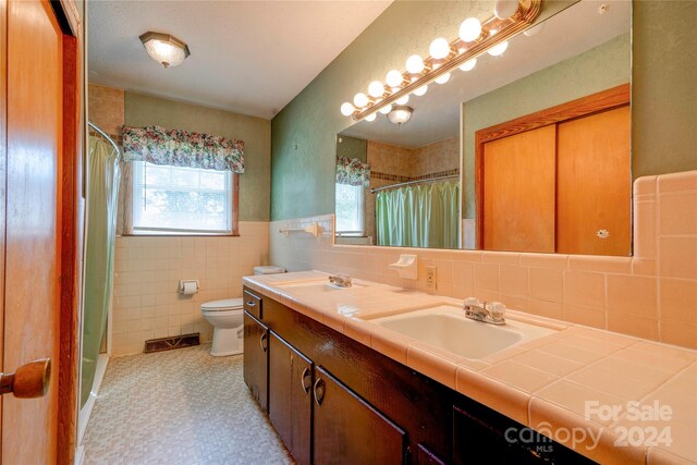 full bathroom featuring vanity, backsplash, tile walls, toilet, and shower / bathtub combination with curtain