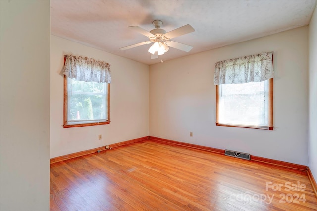 empty room with ceiling fan and light hardwood / wood-style floors