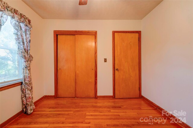 unfurnished bedroom featuring light wood-type flooring and ceiling fan