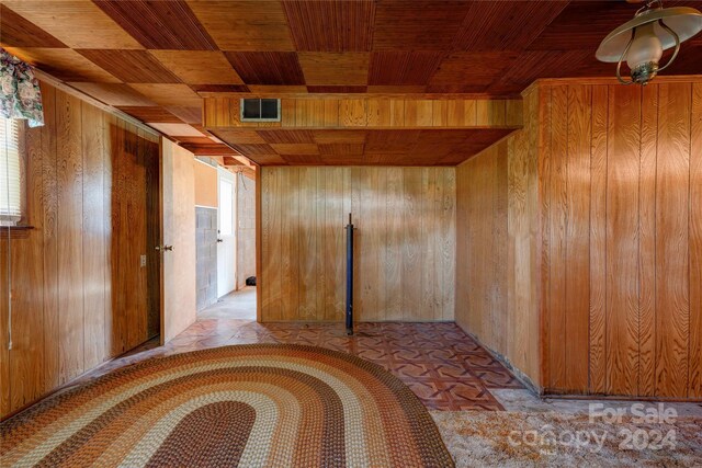 spare room with wooden ceiling and wooden walls