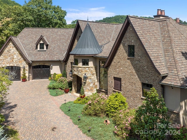 85 Smokey Ridge Trl, Arden, NC 28704 - tudor house featuring stucco siding, driveway, a chimney, stone siding, and a standing seam roof