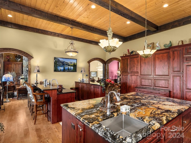 kitchen featuring hanging light fixtures, dark stone countertops, light wood-type flooring, wooden ceiling, and a chandelier