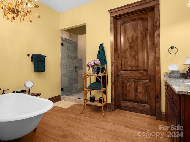 85 Smokey Ridge Trl, Arden, NC 28704 - full bath featuring vanity, a stall shower, wood finished floors, a soaking tub, and a chandelier
