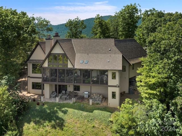 85 Smokey Ridge Trl, Arden, NC 28704 - back of house featuring a sunroom, stucco siding, a patio area, a shingled roof, and a chimney