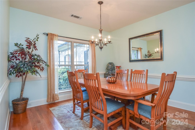 dining space with a notable chandelier, hardwood / wood-style floors, and a wealth of natural light