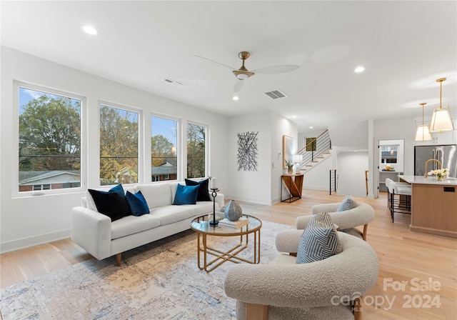 living room with ceiling fan and light wood-type flooring