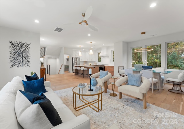 living room with light wood-type flooring and ceiling fan