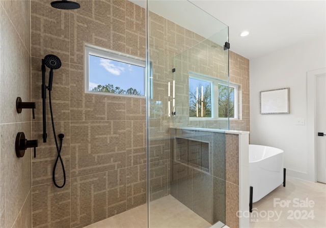 bathroom with tile patterned flooring and separate shower and tub