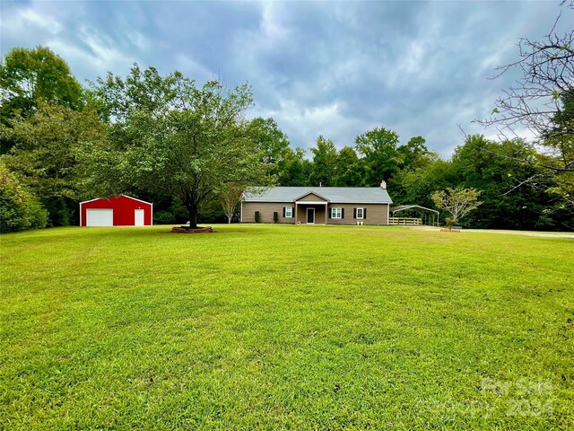 view of yard featuring a garage and an outdoor structure