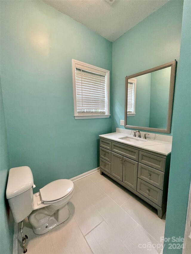 bathroom featuring tile patterned floors, toilet, and vanity