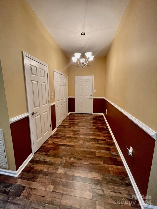 entryway with an inviting chandelier and dark hardwood / wood-style floors