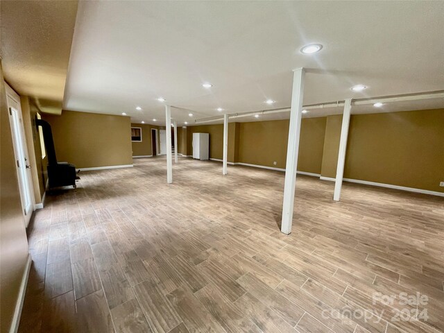 basement with light hardwood / wood-style floors