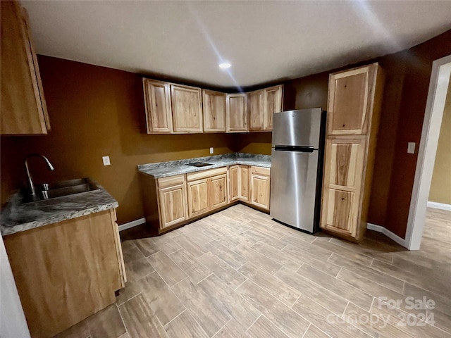 kitchen featuring sink, stainless steel fridge, and light hardwood / wood-style floors