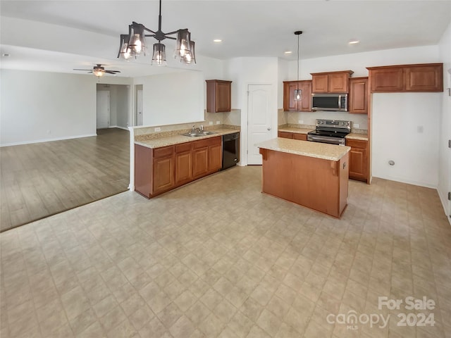 kitchen featuring ceiling fan with notable chandelier, decorative light fixtures, stainless steel appliances, sink, and light wood-type flooring