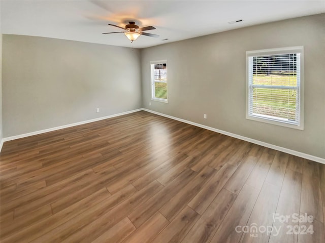 spare room with wood-type flooring, a wealth of natural light, and ceiling fan