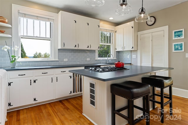 kitchen with pendant lighting, white cabinetry, a wealth of natural light, and a center island