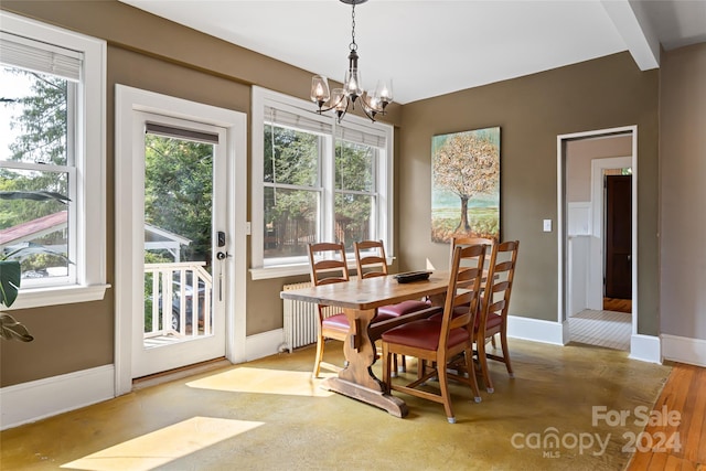 dining space featuring a chandelier, baseboards, radiator heating unit, and wood finished floors