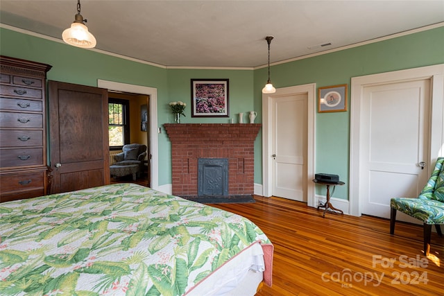 bedroom featuring visible vents, ornamental molding, and wood finished floors
