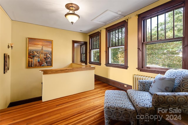 interior space featuring radiator heating unit, baseboards, and wood finished floors