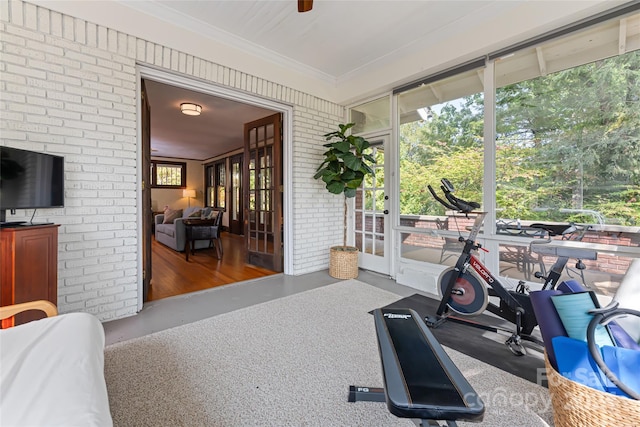 exercise area with dark hardwood / wood-style flooring and brick wall