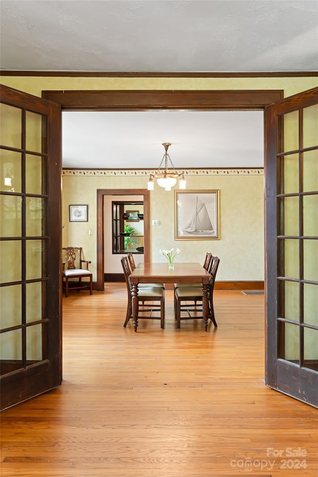 dining area featuring french doors, wood finished floors, and baseboards