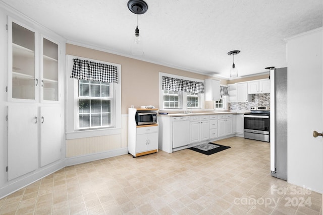 kitchen with hanging light fixtures, appliances with stainless steel finishes, white cabinetry, sink, and a textured ceiling