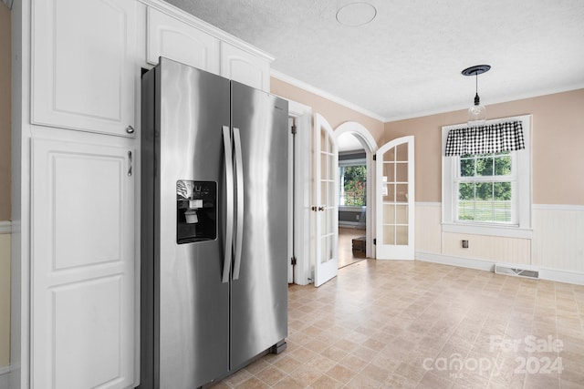 kitchen featuring ornamental molding, white cabinetry, a textured ceiling, decorative light fixtures, and stainless steel fridge with ice dispenser