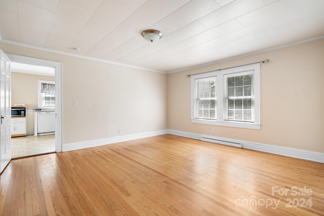 empty room featuring light wood-type flooring, a baseboard heating unit, plenty of natural light, and crown molding