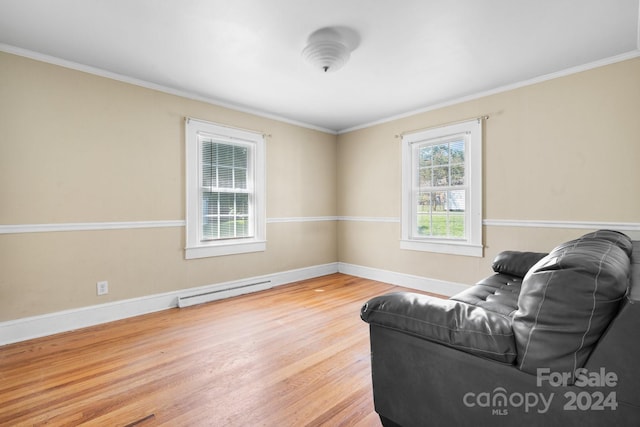 living room featuring crown molding, plenty of natural light, and light hardwood / wood-style flooring