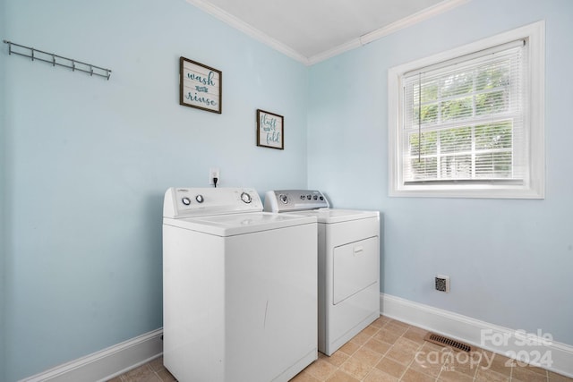 washroom featuring washer and dryer, crown molding, and light tile patterned flooring