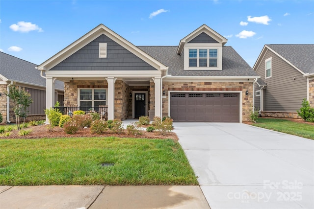 craftsman house featuring a garage, covered porch, and a front lawn