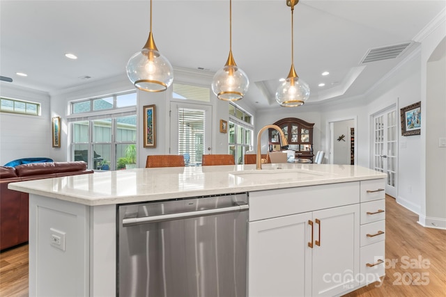 kitchen featuring dishwasher, sink, white cabinets, ornamental molding, and a kitchen island with sink