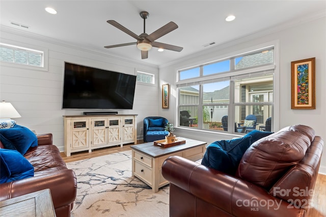 living room featuring crown molding, ceiling fan, and light hardwood / wood-style floors