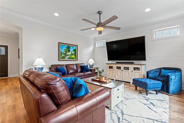 living room featuring crown molding, light hardwood / wood-style floors, and ceiling fan