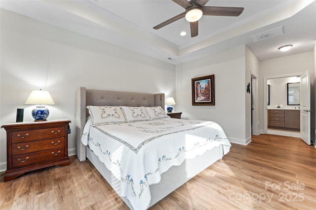 bedroom featuring a tray ceiling, light hardwood / wood-style flooring, ornamental molding, and ceiling fan