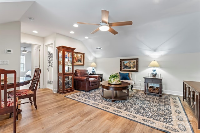 living room featuring lofted ceiling, light hardwood / wood-style flooring, and ceiling fan