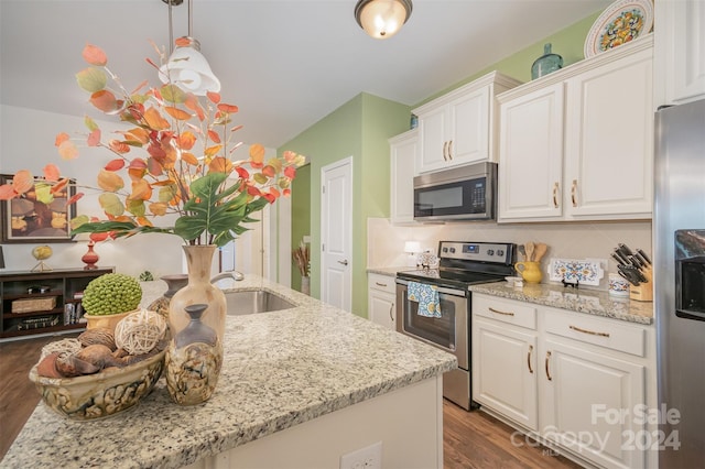 kitchen with dark hardwood / wood-style flooring, appliances with stainless steel finishes, sink, white cabinetry, and light stone counters