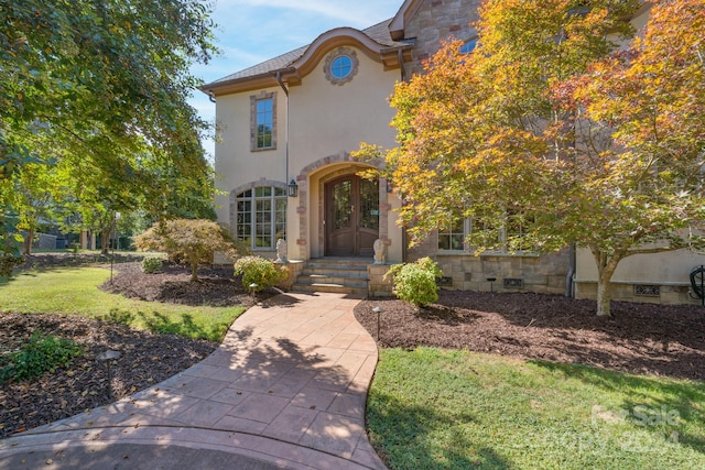 view of front of house with a front yard and french doors