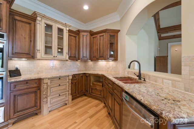 kitchen with light stone countertops, appliances with stainless steel finishes, sink, and decorative backsplash