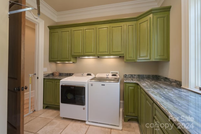 washroom with crown molding, washer and clothes dryer, and cabinets