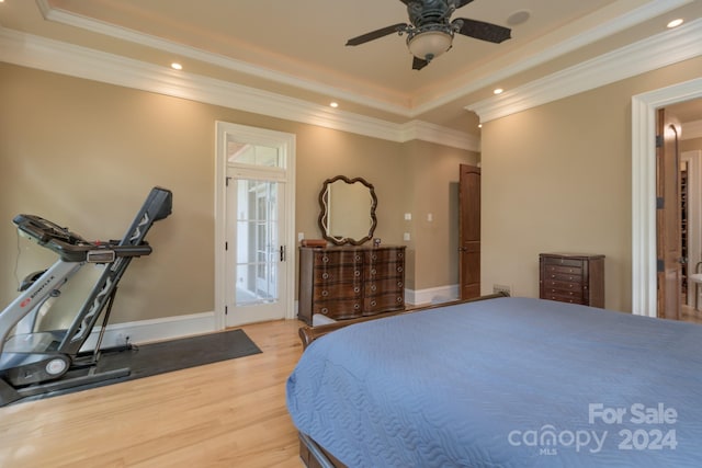 bedroom featuring a tray ceiling, ornamental molding, hardwood / wood-style floors, and ceiling fan