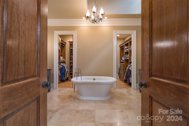 bathroom featuring ornamental molding, a notable chandelier, and a bathtub