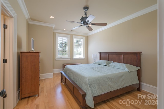 bedroom featuring crown molding, light hardwood / wood-style floors, and ceiling fan