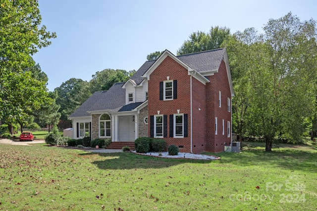 front of property featuring cooling unit and a front lawn