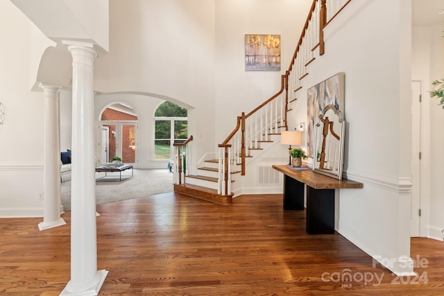 entryway with a high ceiling, ornate columns, dark hardwood / wood-style floors, and french doors