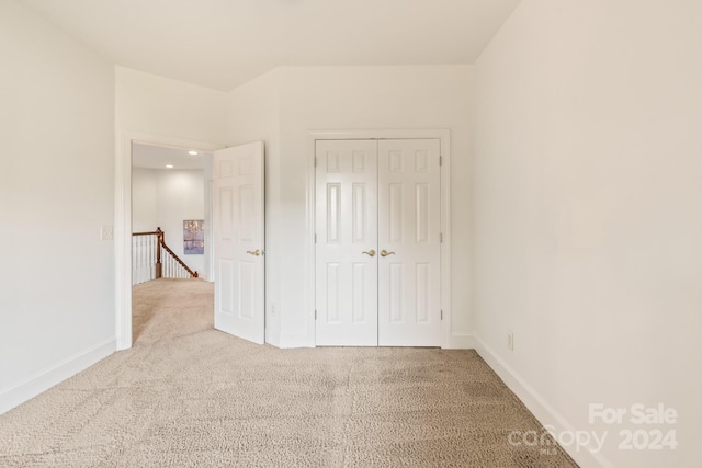 unfurnished bedroom featuring carpet floors and a closet