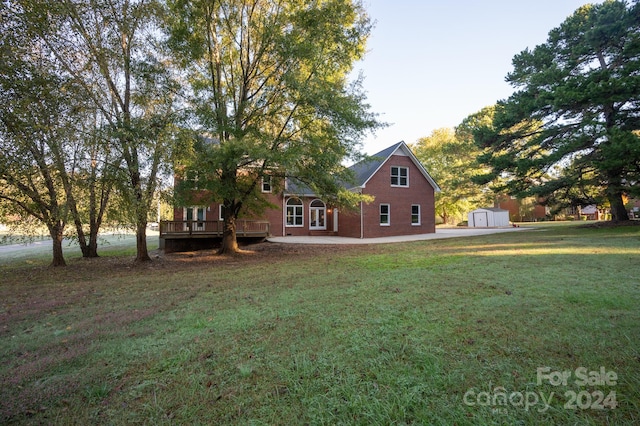 view of yard featuring a storage unit and a deck