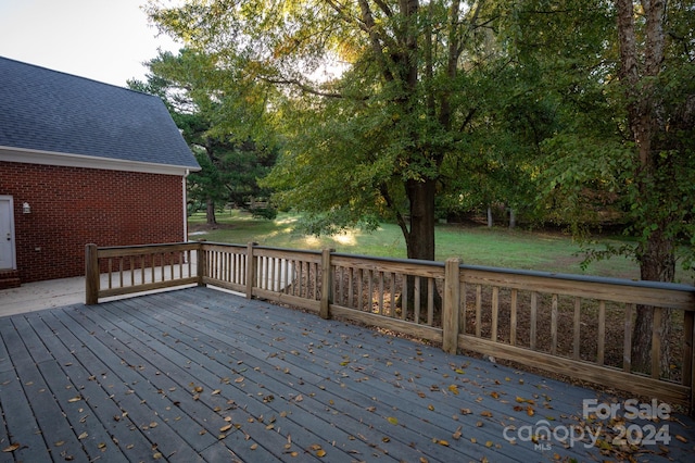 wooden deck featuring a lawn