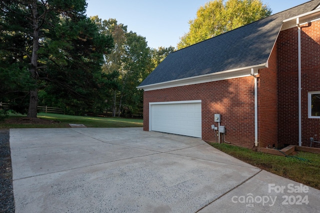 view of property exterior with a garage and a lawn