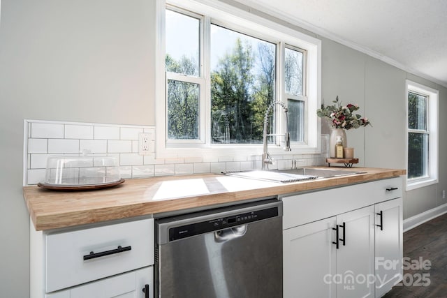 kitchen with dishwasher, wood counters, white cabinetry, and sink